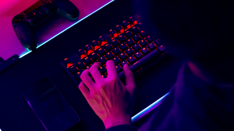 a person playing video games in a dark room with neon lights